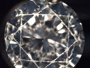 An abraded facet edge in a diamond refers to the condition where the sharp edges of a diamond's facets have become worn, chipped, or dulled.